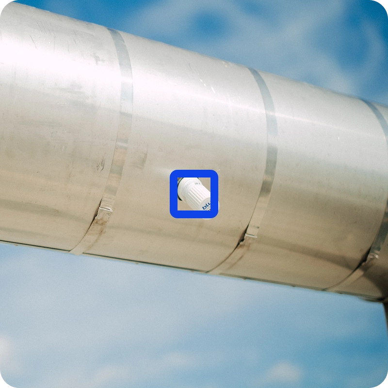 Close-up of a bluZenit wireless corrosion monitoring sensor mounted on an insulated pipe